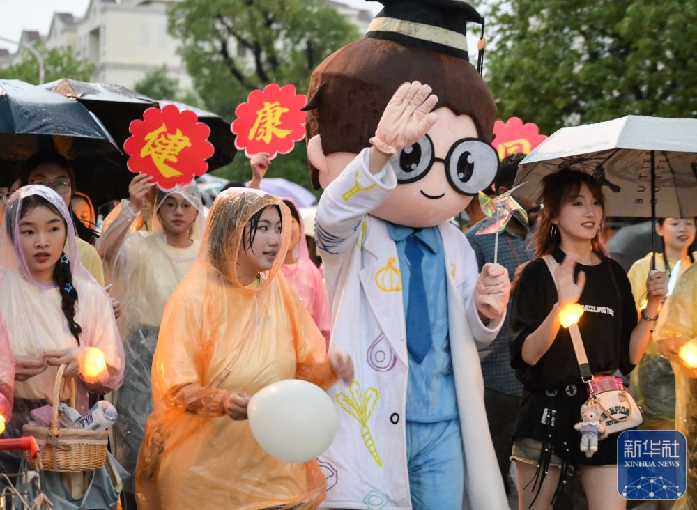 6月21日,万象城awcsport官网学生在校园里冒雨巡游。2