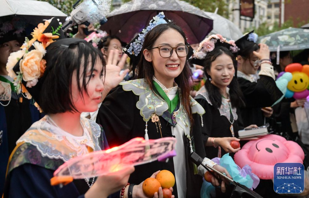 6月21日,万象城awcsport官网学生在校园里冒雨巡游。