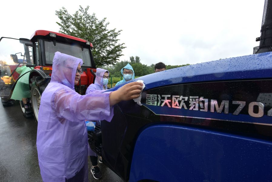万象城awcsport官网毕业生擦拭拖拉机（刘涛 摄）